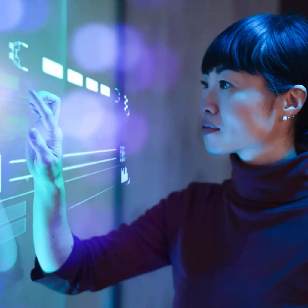 A woman interacts with a digital see-through interface directly in front of her.